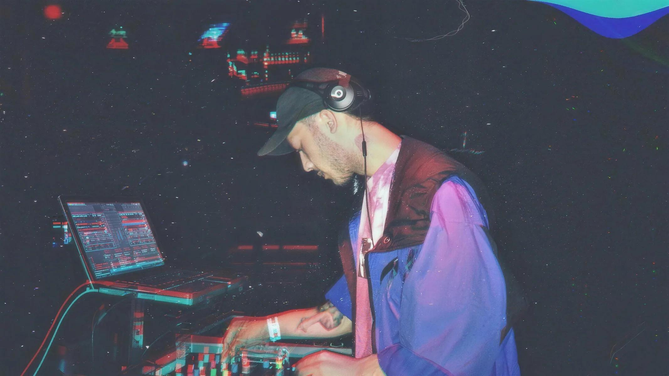 BDJ working a dark club booth, the room washed in red