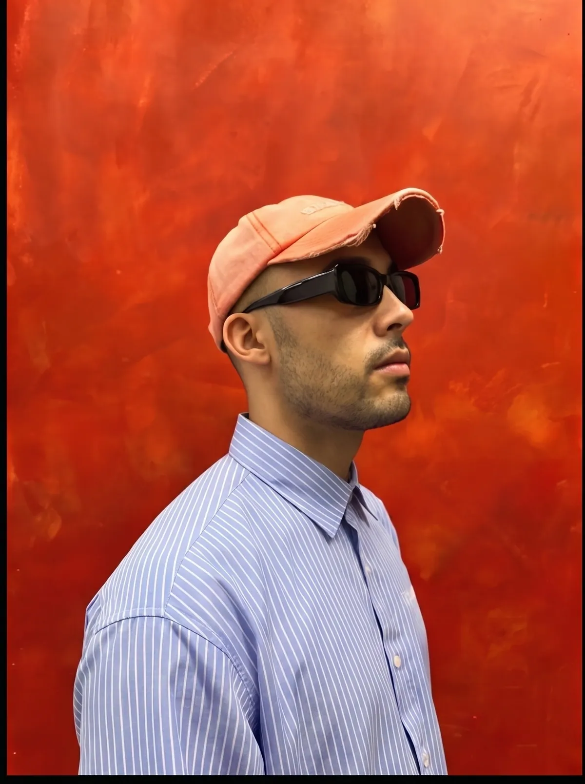 Profile portrait of BDJ against a red wall
